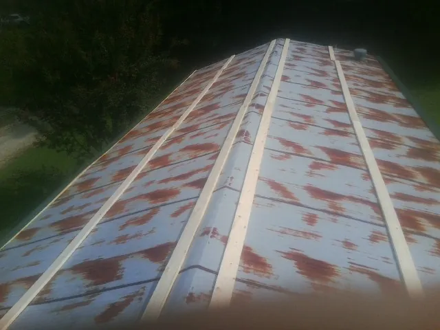 Rusted metal roof panels with new wood purlins before replacement — Storm Damage Roof Repair in Buna by Roofing Brothers